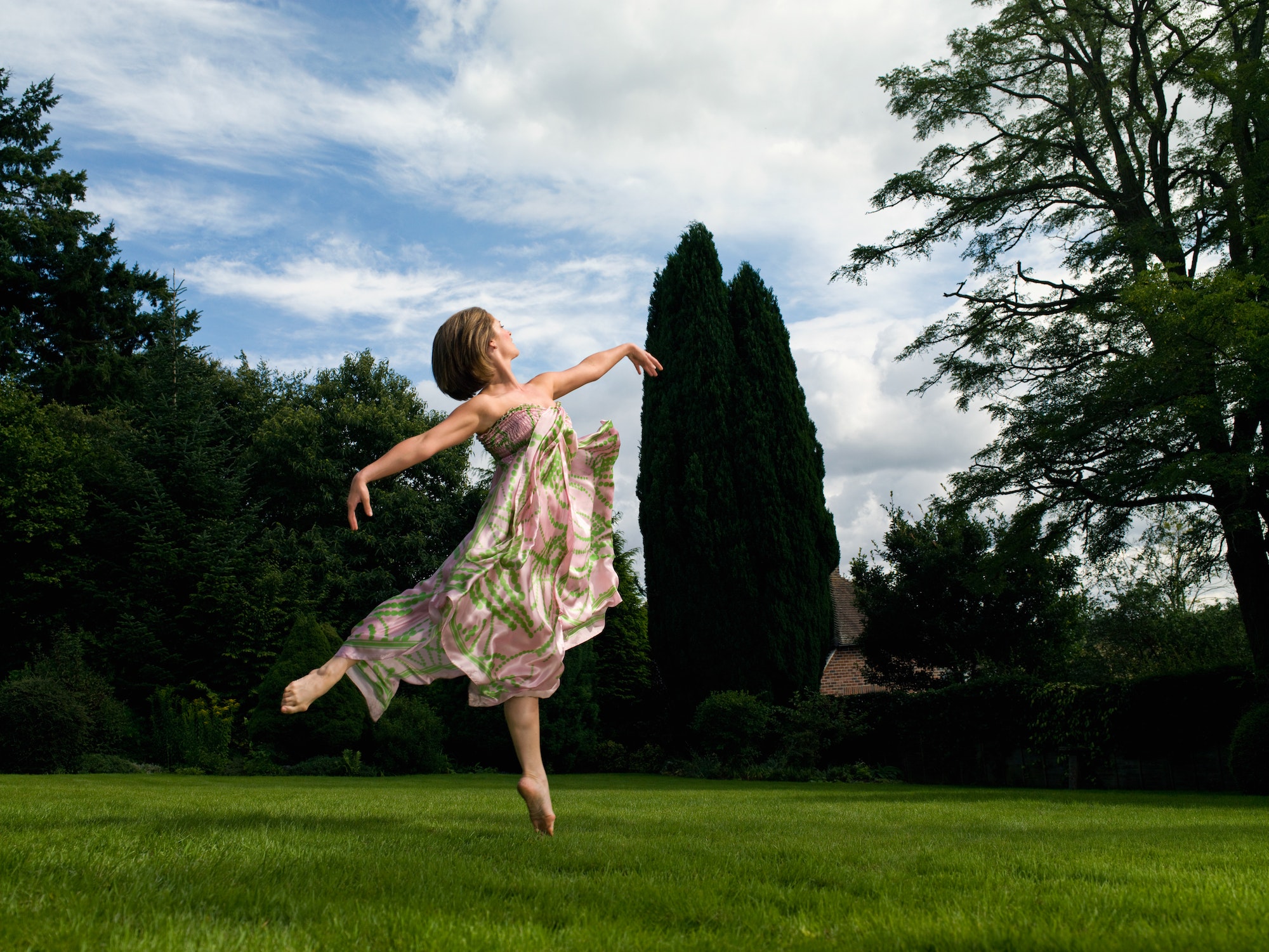 A young woman dancing in a garden